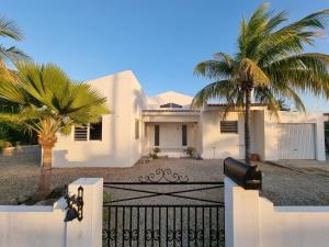 Biały dom z palmami przed nim w obiekcie Kaya Venus Bonaire w mieście Kralendijk
