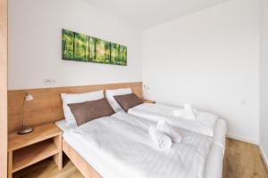 a bedroom with two beds with white sheets at Deluxe Apartment Lipno - Lake Side Village, Frymburk nad Vltavou in Frymburk