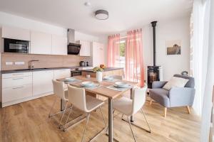 a kitchen and dining room with a wooden table and chairs at Deluxe Apartment Lipno - Lake Side Village, Frymburk nad Vltavou in Frymburk