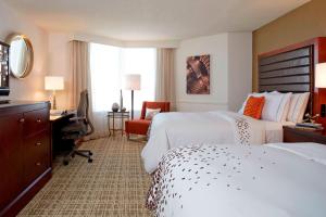 a hotel room with two beds and a desk at Renaissance St. Louis Airport Hotel in Saint Louis