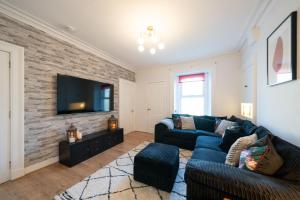 a living room with two couches and a flat screen tv at Seaside Home in Stonehaven, Aberdeenshire in Stonehaven