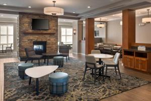 a lobby with tables and chairs and a fireplace at Residence Inn Silver Spring in Silver Spring