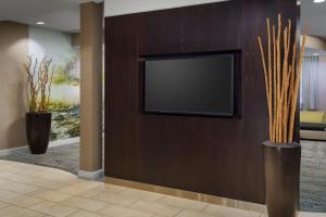 einen Fernseher an einer Wand in einer Lobby mit zwei Vasen in der Unterkunft Courtyard by Marriott Roseville Galleria Mall/Creekside Ridge Drive in Roseville