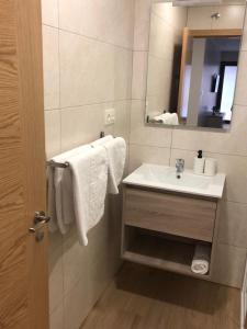 Baño blanco con lavabo y espejo en SOPHIE APARTAMENTOS en Burela de Cabo