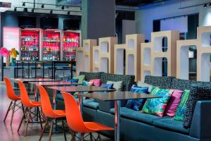 a restaurant with tables and a couch and chairs at Aloft Tallahassee Downtown in Tallahassee