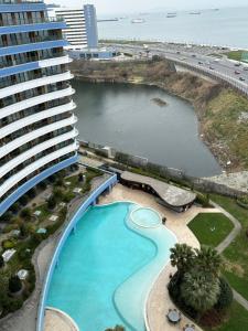 a large building with a swimming pool next to a beach at Ottomare Suites sea, view, pool, gym in Istanbul