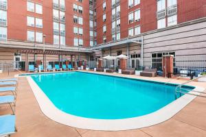 a large swimming pool in front of a building at Aloft Tallahassee Downtown in Tallahassee