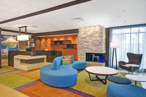 eine Lobby mit blauen Stühlen und Tischen sowie ein Wohnzimmer in der Unterkunft Fairfield Inn & Suites by Marriott Savannah SW/Richmond Hill in Richmond Hill