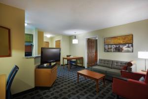 a living room with a couch and a flat screen tv at TownePlace Suites Tampa North I-75 Fletcher in Tampa