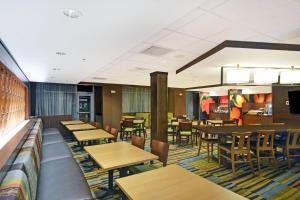 ein Restaurant mit Holztischen und -stühlen und einer Bar in der Unterkunft Fairfield Inn & Suites by Marriott Savannah SW/Richmond Hill in Richmond Hill