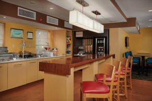 a kitchen with a counter with chairs and a bar at TownePlace Suites Tampa North I-75 Fletcher in Tampa