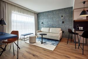 sala de estar con sofá y mesa en Residence Inn by Marriott Strasbourg, en Estrasburgo