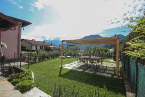 een tuin met een tafel en een prieel bij Casa Kika - Lenno by LoveComo in Lenno