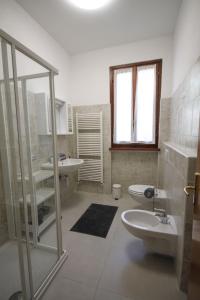 a white bathroom with a sink and a toilet at Casa Kika - Tremezzina Lenno in Lenno