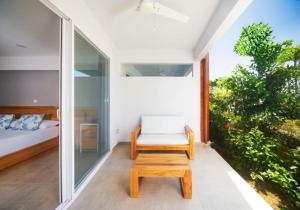 een kamer met een bed, een stoel en een tafel bij Naboo Resort & Dive Center - Adults Only in West Bay