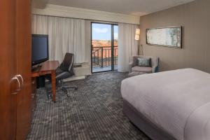 Habitación de hotel con cama, escritorio y TV. en Courtyard by Marriott Gaithersburg Washingtonian Center, en Gaithersburg