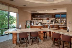 a bar in a restaurant with chairs and a counter at Courtyard by Marriott Gaithersburg Washingtonian Center in Gaithersburg