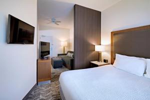 a hotel room with a bed and a television at SpringHill Suites Phoenix Glendale/Peoria in Peoria