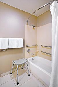 een badkamer met een bad en een kruk erin bij SpringHill Suites Phoenix Glendale/Peoria in Peoria