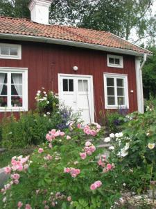 a red house with a white door and some flowers at Lillåns B&B in Örebro