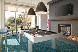 a living room with a pool table and a fireplace at Aloft Mountain View in Mountain View