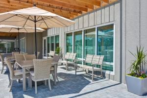 a patio with tables and chairs and an umbrella at TownePlace Suites by Marriott Panama City Beach Pier Park in Panama City Beach