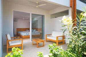 une chambre avec un lit et des chaises dans l'établissement Naboo Resort & Dive Center - Adults Only, à West Bay