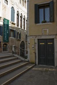 um edifício com uma porta preta e escadas ao lado de um edifício em I Gioielli del Doge - Topazio em Veneza