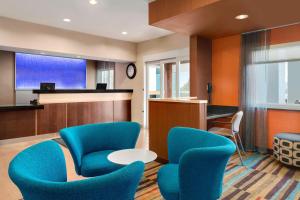 a waiting room with blue chairs and a table at Fairfield Inn & Suites Lima in Lima