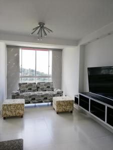 Apartamento Lux Confort في فلوريدا بلانكا: غرفة معيشة مع أريكة وتلفزيون بشاشة مسطحة