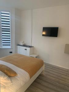 a bedroom with a bed and a television on the wall at Bloomsbury House - Modern studios near Anfield in Liverpool