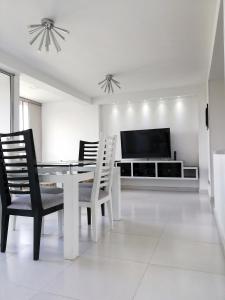 Apartamento Lux Confort في فلوريدا بلانكا: غرفة طعام مع طاولة وكراسي وتلفزيون