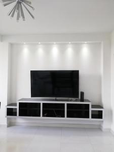 sala de estar con TV en una pared blanca en Apartamento Lux Confort, en Floridablanca