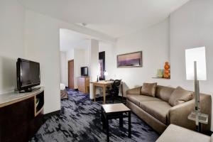 Fairfield Inn and Suites by Marriott San Antonio Boerne في بويرن: غرفة معيشة مع أريكة وتلفزيون بشاشة مسطحة