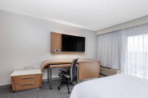 a hotel room with a desk and a television at Courtyard by Marriott Reno in Reno