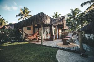a resort with a hammock outside of a house at Madeiro Beach Hotel in Pipa