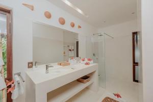 a white bathroom with a sink and a shower at Madeiro Beach Hotel in Pipa