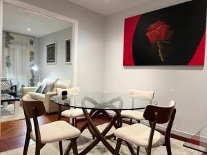 a dining room with a glass table and chairs at Céntrico y acogedor piso con garaje in A Coruña +14 photos