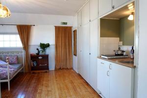 a kitchen with white cabinets and a wooden floor at Betel Hem in Hällefors