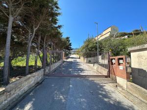 una puerta en un camino con una valla en Villa FIORENZA - 100 mt dal Mare en Castellammare del Golfo