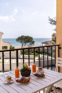 uma mesa branca com comida e bebidas numa varanda em ~ Villa Demetra ~ em Noto Marina