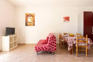 uma sala de jantar com uma mesa e cadeiras e uma televisão em ~ Villa Demetra ~ em Noto Marina