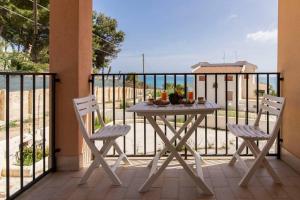 d'une table et de deux chaises sur un balcon donnant sur l'océan. dans l'établissement ~ Villa Demetra ~, à Noto Marina