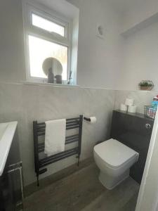 a bathroom with a toilet and a sink and a window at DaisyChain Getaways at Chaney Rd in Wivenhoe +13 photos