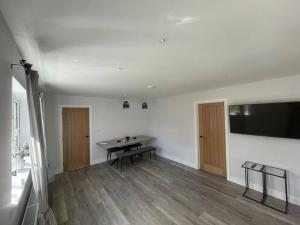 a room with a ping pong table and a flat screen tv at DaisyChain Getaways at Chaney Rd in Wivenhoe