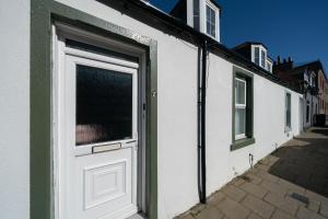 a white door on the side of a building at Seaside Home in Stonehaven, Aberdeenshire in Stonehaven