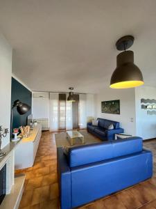 ein Wohnzimmer mit einem blauen Sofa und einem Tisch in der Unterkunft PanoramApartment in Desenzano del Garda