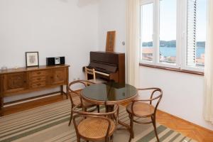 een eetkamer met een tafel en stoelen en een piano bij Piano Apartment in Šibenik