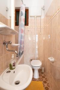 een badkamer met een witte wastafel en een toilet bij Piano Apartment in Šibenik