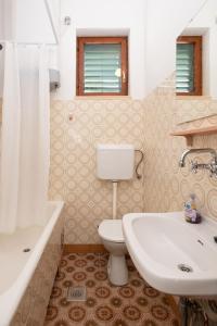 een badkamer met een wit toilet en een wastafel bij Piano Apartment in Šibenik
